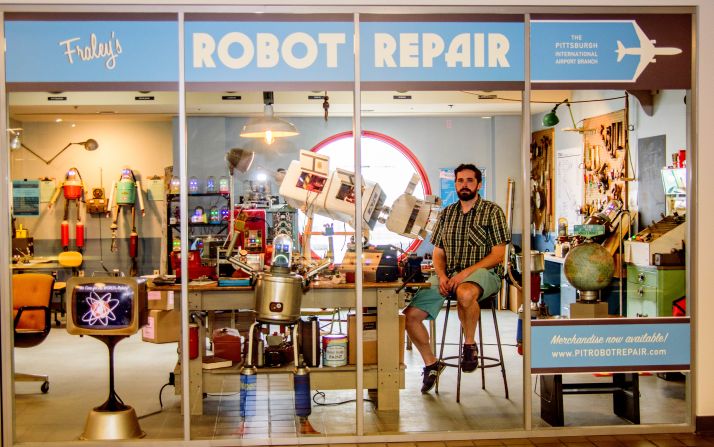 As a self-proclaimed "aviation junkie," artist Toby Fraley was excited by the idea of having his award-winning robot repair shop displayed in an airport. Fliers passing through Pittsburgh International can enjoy the retro-futuristic installation. 