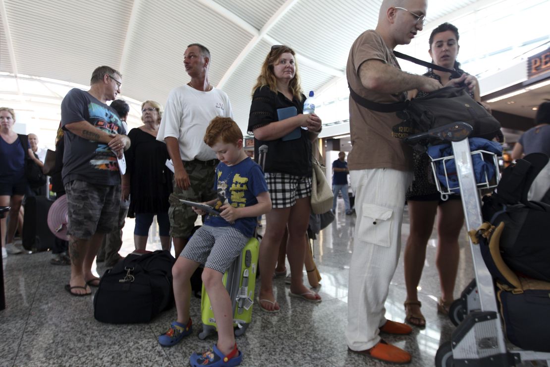 Passengers line up to check the status of their flights at Ngurah Rai International Airport in Bali, Indonesia on November 4, 2015.