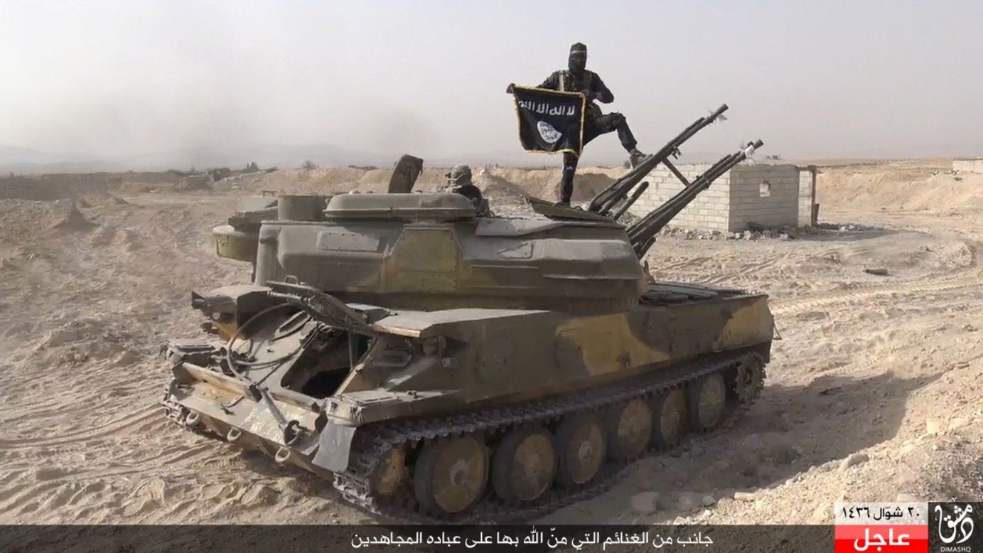 In this image taken from social media, an ISIS fighter holds the group's flag as he stands on a tank, purportedly captured when they took over the town of Qaryatain, Syria. ISIS, along with Boko Haram, is one of two groups accounting for 51% of claimed terrorism deaths in 2014. 