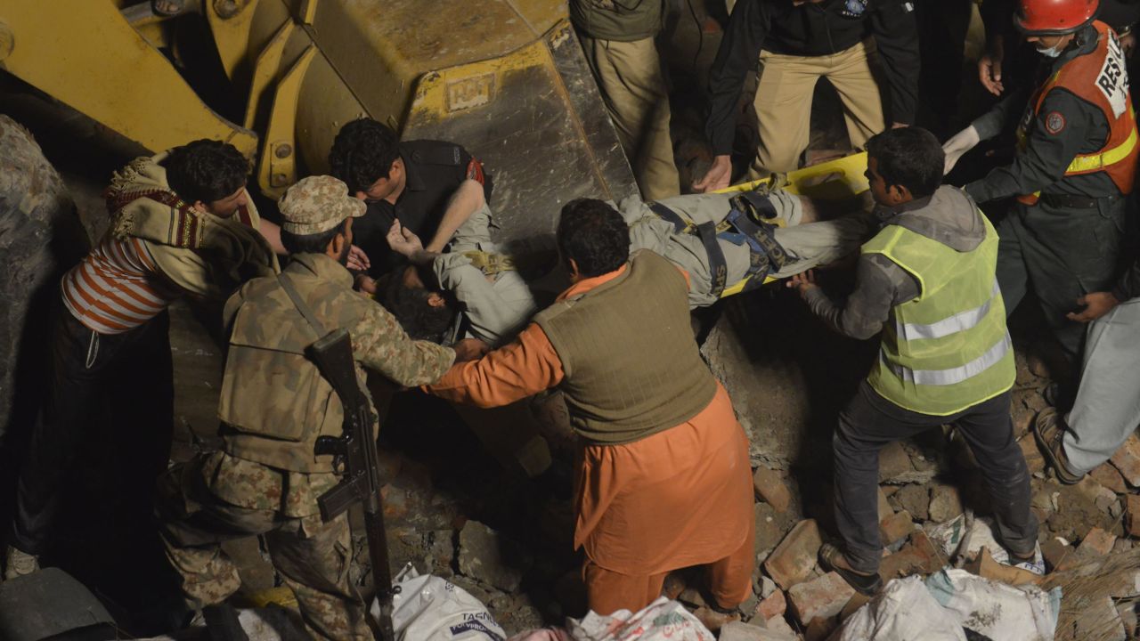 A Pakistani soldier and rescuers move a victim through the rubble of a collapsed factory on the outskirts of Lahore on November 4.