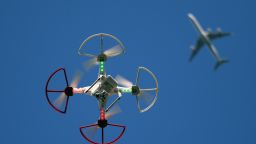 A drone is flown for recreational purposes as an airplane passes nearby in the sky above Old Bethpage, New York on September 5, 2015. 