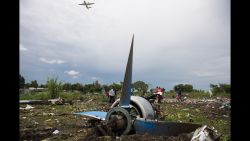 People gather at the site of a cargo plane crash, on a small island in the White Nile river, close to Juba airport, in the Hai Gabat residential area, on November 4, 2015. At least 27 people were killed today when a plane crashed shortly after taking off from South Sudan's capital Juba, an AFP reporter said. Police were pulling the bodies of men, women and children out of the wreckage of the Russian-built Antonov An-12 cargo plane, which smashed into a farming community on an island on the White Nile river, according to the reporter, who counted at least 27 dead.  AFP PHOTO / CHARLES LOMODONG        (Photo credit should read CHARLES LOMODONG/AFP/Getty Images)