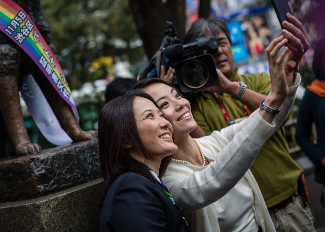 Japanese couple Hiroko Masuharda and Koyuki Higashi celebrate in front of Shibuya's Hachiko statue on November 5, 2015.