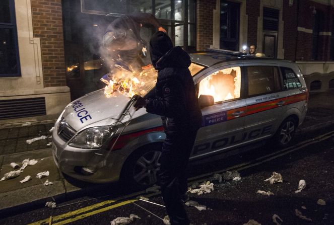A police car is burned during the anti-capitalist Million Mask March near the British Houses of Parliament in London on Thursday November 5. The hacker group Anonymous organized the protest.