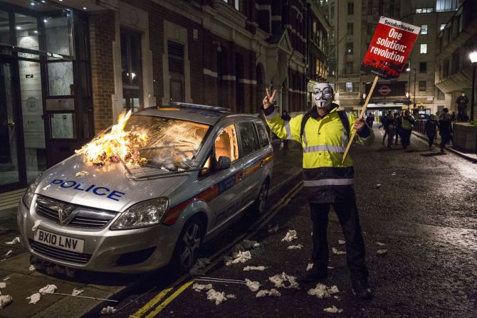 An unattended police car is set on fire in Queen Anne's Gate in central London during the protest on Guy Fawkes Night, an annual commemoration in the UK of a failed plot to kill King James I in 1605.