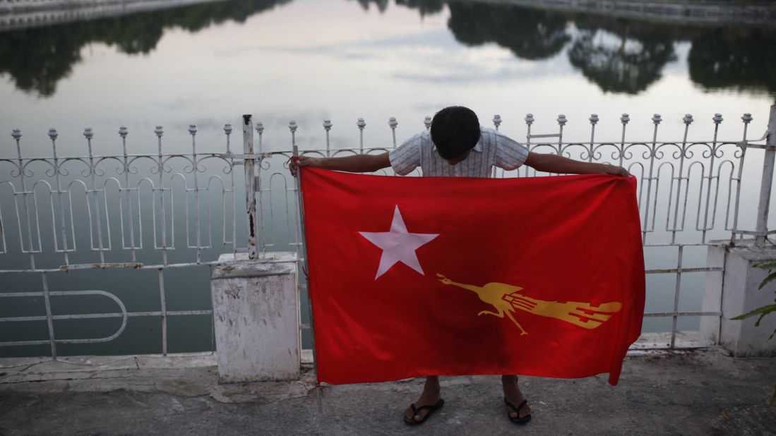 A supporter of Aung San Suu Kyi's National League for Democracy party holds a party flag in Mandalay on November 5.