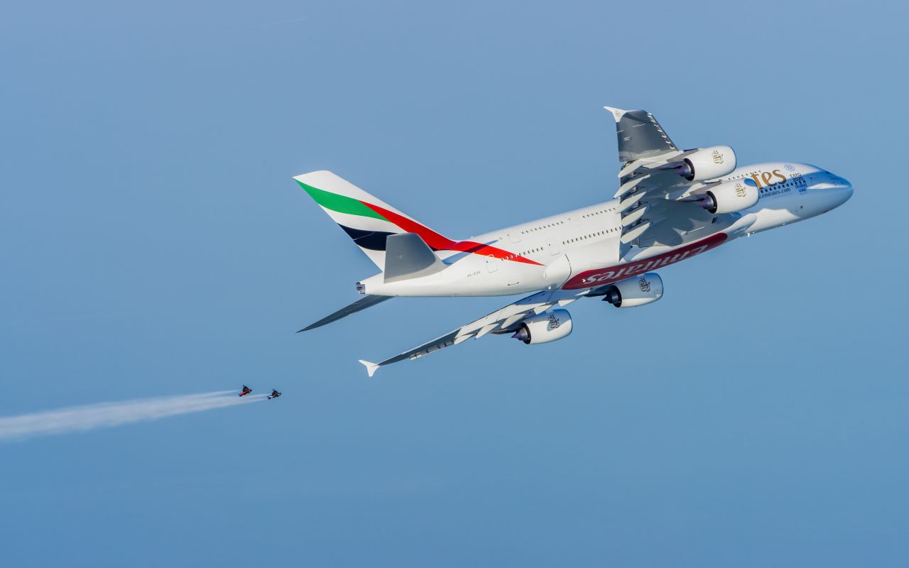 Soaring above the city's famous Palm Jumeriah islands, the pair are dwarfed by the massive passenger jet, the largest in the world. 