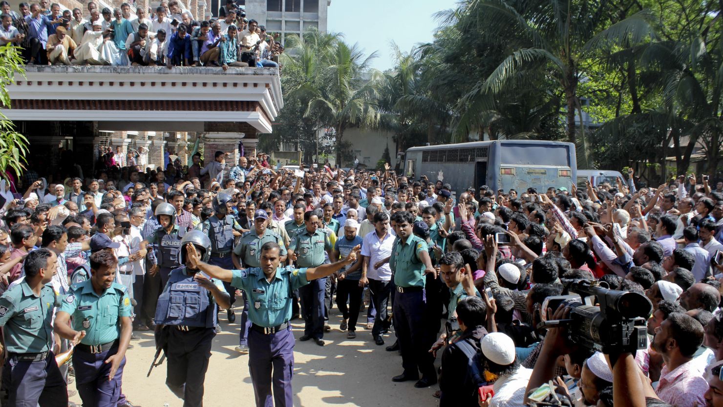 People gather outside a court as police escort the accused in the killing of Samiul Islam Rajon before a verdict in Sylhet, Bangladesh, on November 8, 2015.