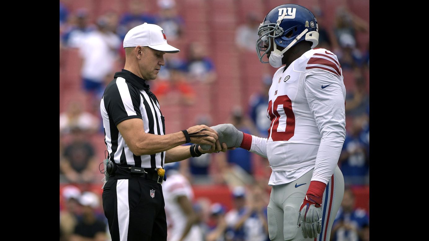 NFL referee Clete Blakeman checks the taped-up hand of Jason Pierre-Paul before an NFL game in Tampa, Florida, on Sunday, November 8. It was Pierre-Paul's first game back since injuring his hand in a fireworks accident during the offseason.
