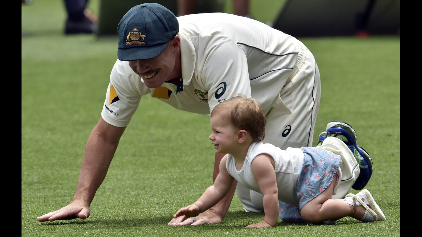 Australian cricketer David Warner crawls with his daughter, Ivy, after a Test victory over New Zealand on Monday, November 9.