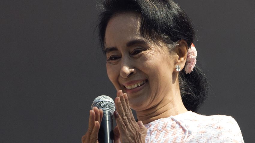 Leader of Myanmar's opposition National League for Democracy party, Aung San Suu Kyi, with ink still imprinted on the little finger of her left hand after voting Sunday, delivers a speech from a balcony of the NLD headquarters in Yangon, Myanmar, Monday, Nov. 9, 2015. Suu Kyi on Monday hinted at a victory by her party in the country's historic elections, and urged supporters not to provoke their losing rivals who are backed by the military.(AP Photo/Mark Baker)