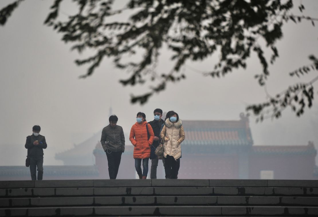 Citizens wearing masks walk in the smog at the Mukden Palace on November 8, 2015 in Shenyang, Liaoning Province of China. 