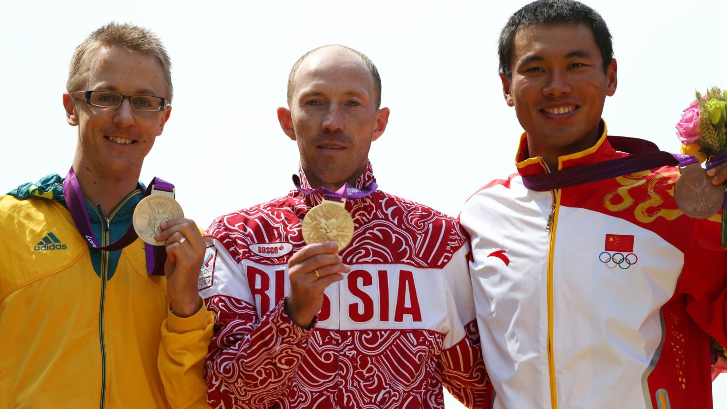 Jared Tallent stands next to Russian gold medalist Sergey Kirdyapkin (center) during a London 2012 Olympics medal ceremony. Tallent says he was robbed of first place by Kirdyapkin, a known drug cheat. 