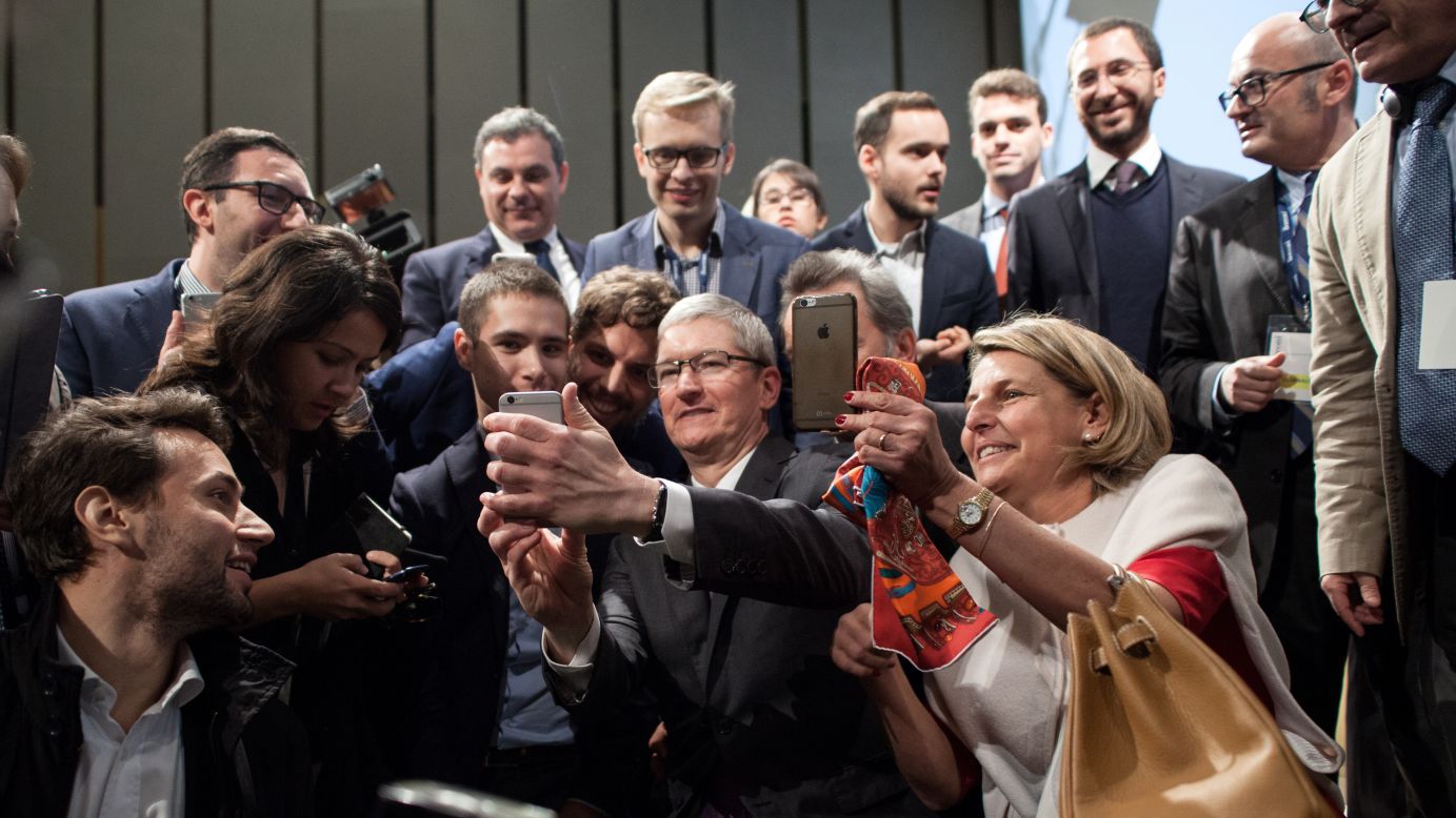 Apple CEO Tim Cook holds his phone as he takes a selfie Tuesday, November 10, at Bocconi University in Milan, Italy. Cook was a guest speaker at the school.