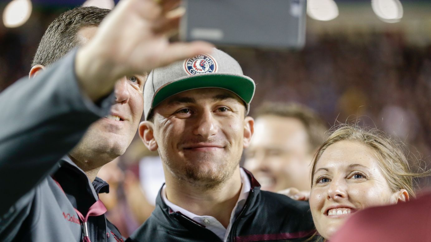 NFL quarterback Johnny Manziel smiles as he takes a photo with fans at his alma mater, Texas A&M, on Saturday, November 7. Manziel was attending the school's football game against Auburn.