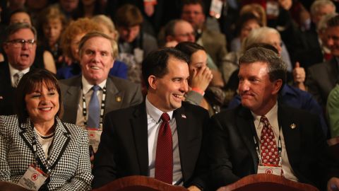 Wisconsin Gov. Scott Walker, center, sits in the audience. He dropped out of the presidential race in September.