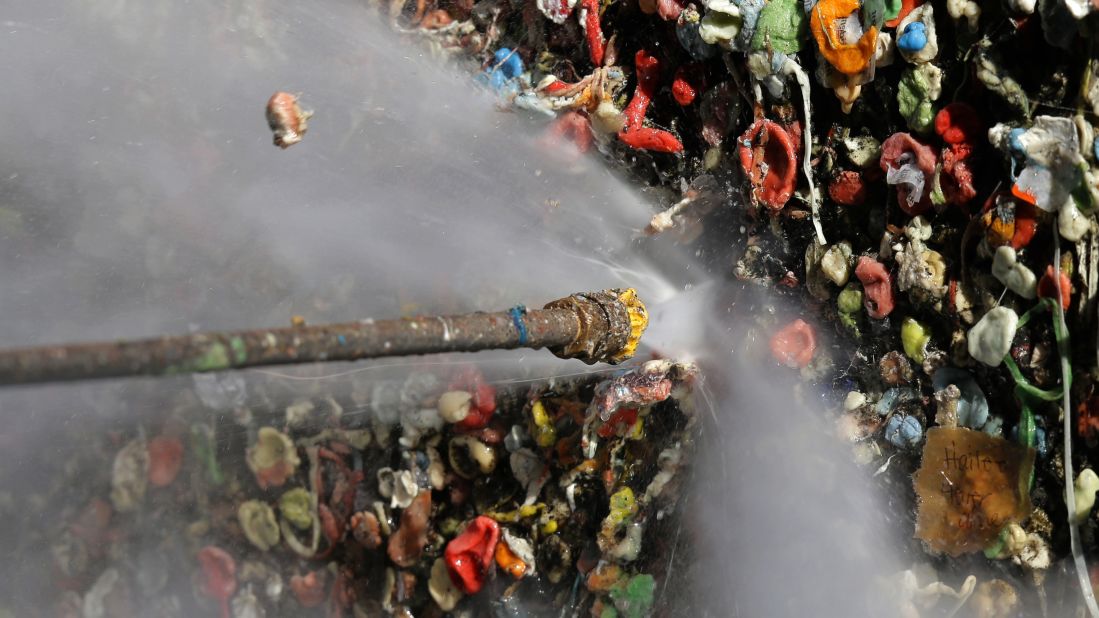 A worker uses a high-temperature pressure washer to clean layers of gum from Seattle's famous gum wall at Pike Place Market on Tuesday, November 10. Tourists and locals have been sticking their used chewing gum on the walls of a section of Post Alley for the past 20 years.