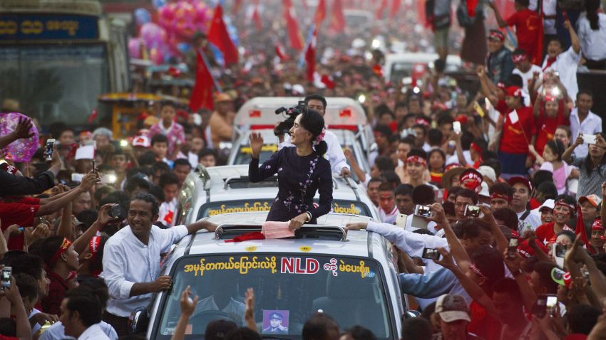 Myanmar opposition leader Aung San Suu Kyi gestures towards supporters as she travels in a motorcade ahead of a campaign rally for the National League for Democracy in Yangon on November 1, 2015. Myanmar heads to the polls on November 8 in what observers and voters hope will be the fairest election in decades as the nation slowly shakes off years of brutal and isolating junta rule.  AFP PHOTO / Ye Aung THU        (Photo credit should read Ye Aung Thu/AFP/Getty Images)