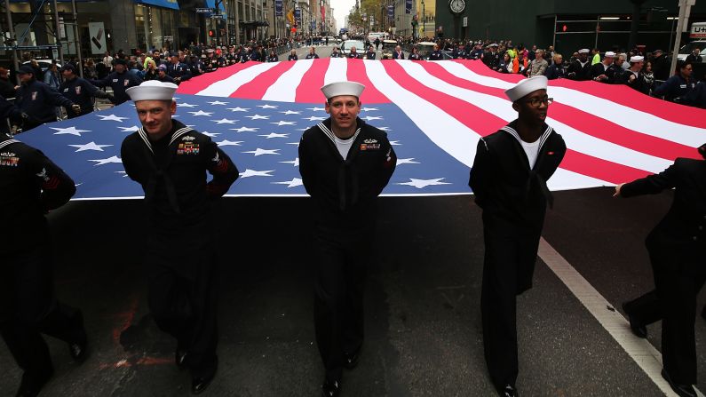 Members of the U.S. Navy march with the American flag during a Veterans Day parade in New York City on Wednesday, November 11.
