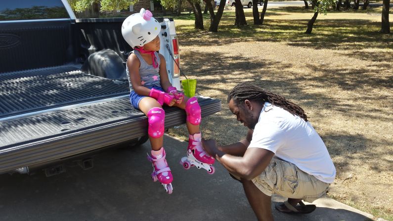 Kaylee got new skates for her birthday and Chris is helping her put them on in this photo.