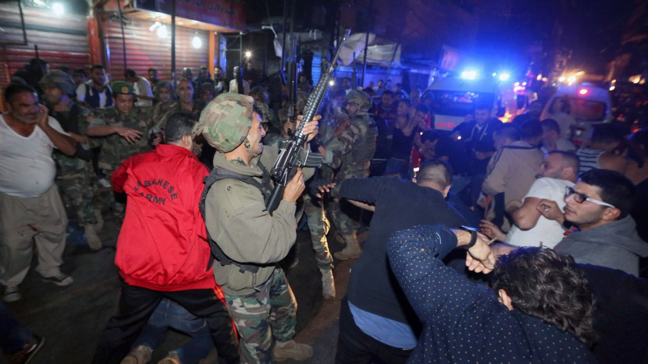 A Lebanese soldier opens fire into the air to disperse people who gathered around a man on the ground whom they claimed was a suspected attacker.
