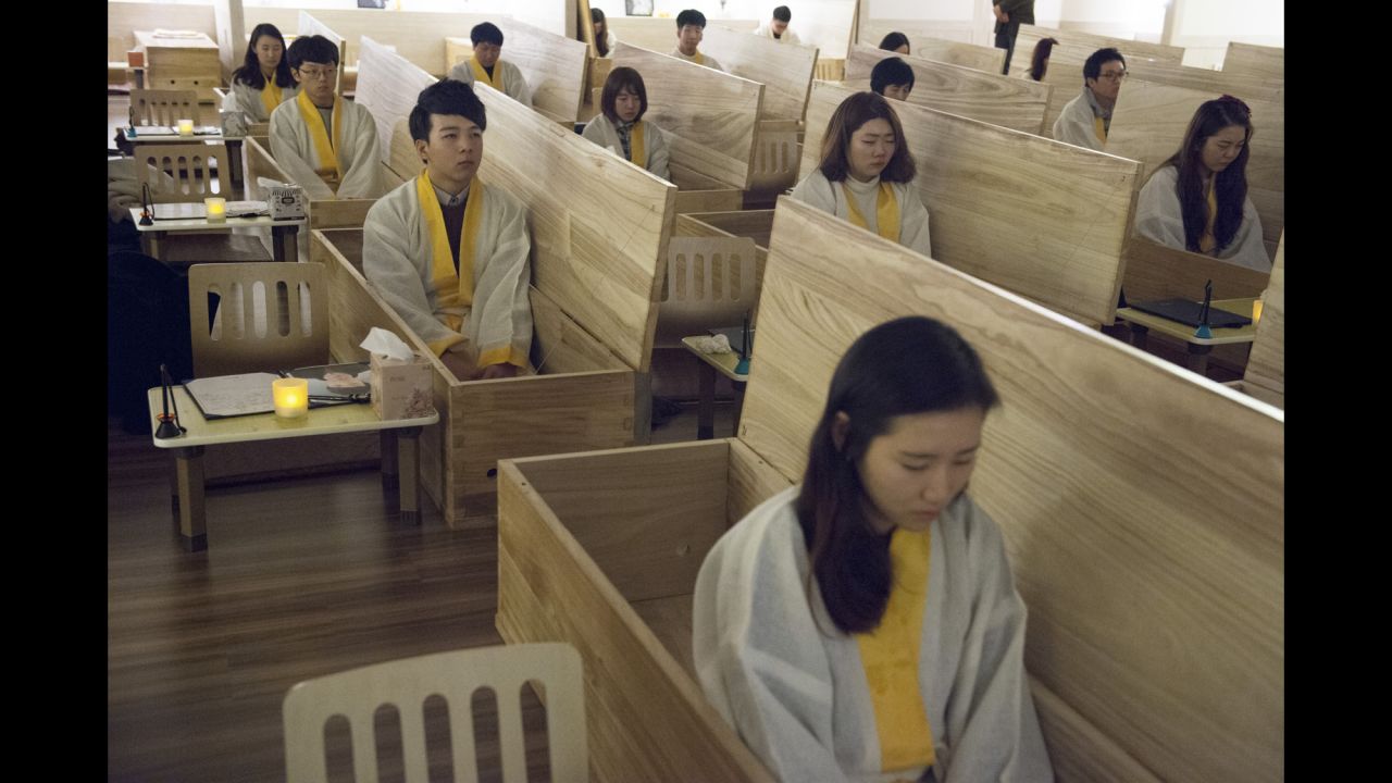 People sit in wooden coffins at the Hyowon Healing Center in Seoul, South Korea. It's where groups of people who might be struggling with depression, stress or suicidal thoughts go to act out their own funerals. After the emotional, personal experience, some seemed to leave feeling happier, photographer Françoise Huguier said.
