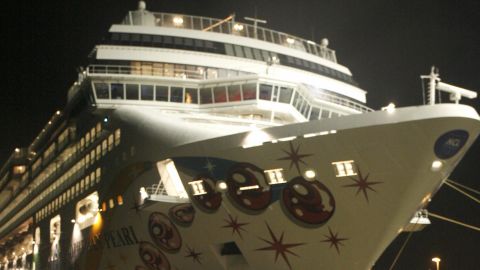 Papenburg, GERMANY: Residents watch as the cruise ship Norwegian Pearl sails through a narrow portion of the river Elms, before entering the North Sea late 04 November 2006. German authorities are still investigating whether the power surge caused when high voltage cables close to the river were turned back on after the ship had completed its passage, was partly responsible for the power cut experienced in most of western Europe late 04 November. AFP PHOTO DDP/NIGEL TREBLIN GERMANY OUT (Photo credit should read NIGEL TREBLIN/AFP/Getty Images)