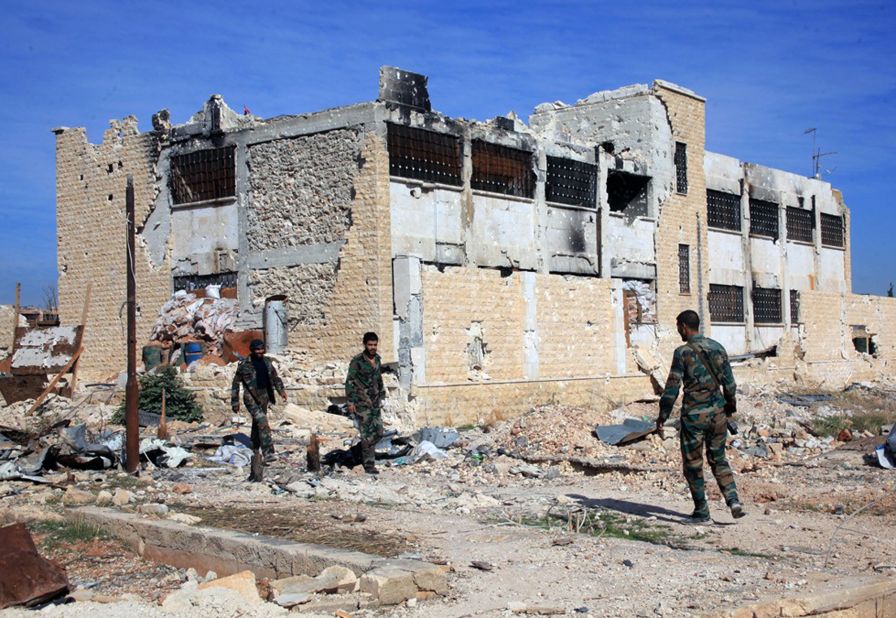 Syrian government troops walk inside the Kweiras air base on Wednesday, November 11, after they broke a siege imposed by ISIS militants.