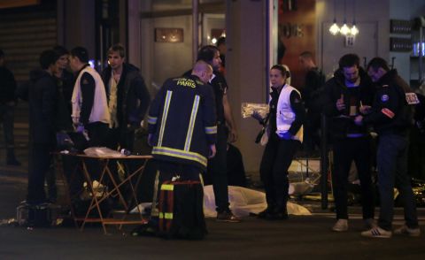Rescue workers and medics tend to victims at the scene of one of the shootings, a restaurant in the 10th District. Attackers reportedly used AK-47 automatic weapons in separate attacks across Paris, and there were explosions at the Stade de France.