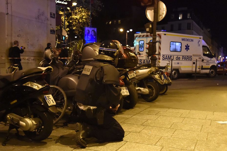A riot police officer stands by an ambulance near the Bataclan concert hall in central Paris.