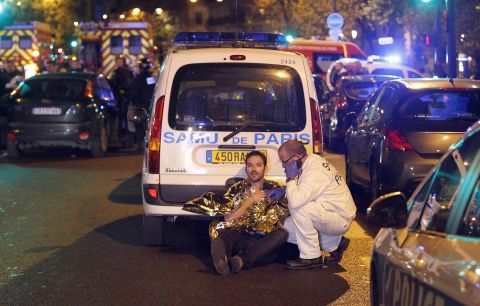 A medic tends to a wounded man following the attacks near the Boulevard des Filles du Calvaire.