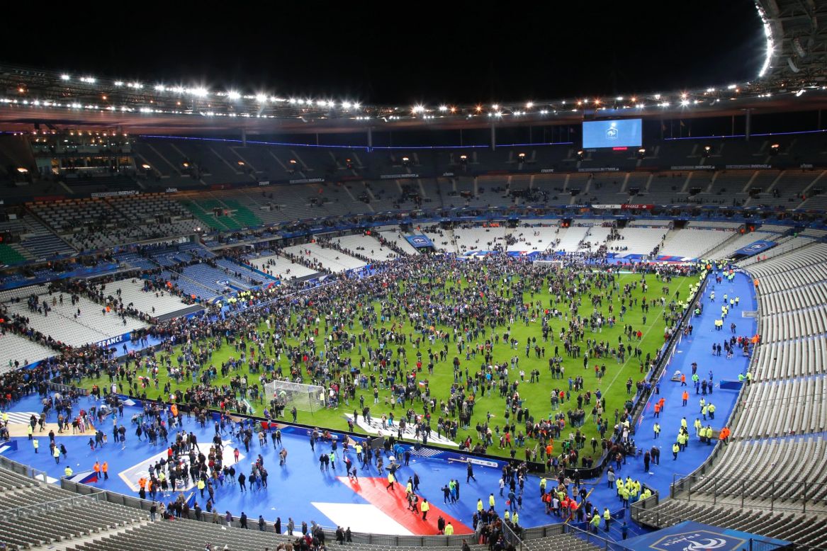 Spectators gather on the field of the Stade de France after the attacks. Explosions were heard during the soccer match between France and Germany.