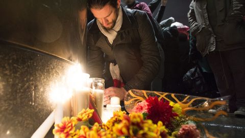 People light candles at a vigil outside the French Consulate in Montreal on November 13. 