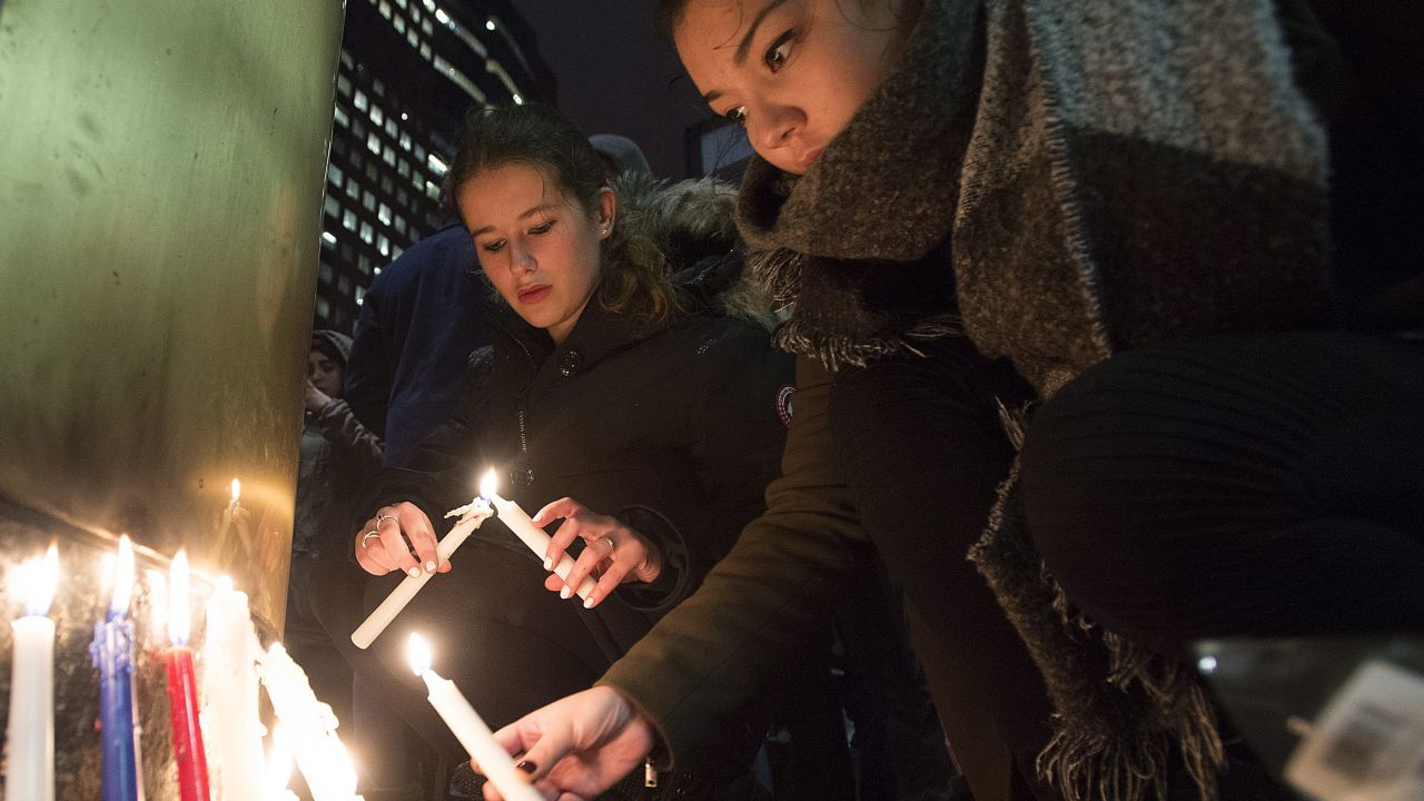 People light candles at a vigil outside the French consulate in Montreal, Friday, Nov. 13, 2015. Canadian Prime Minister Justin Trudeau offered "all of Canada's support" to France on Friday night in the wake of "deeply worrying" terrorist attacks in Paris. (Graham Hughes/The Canadian Press via AP)