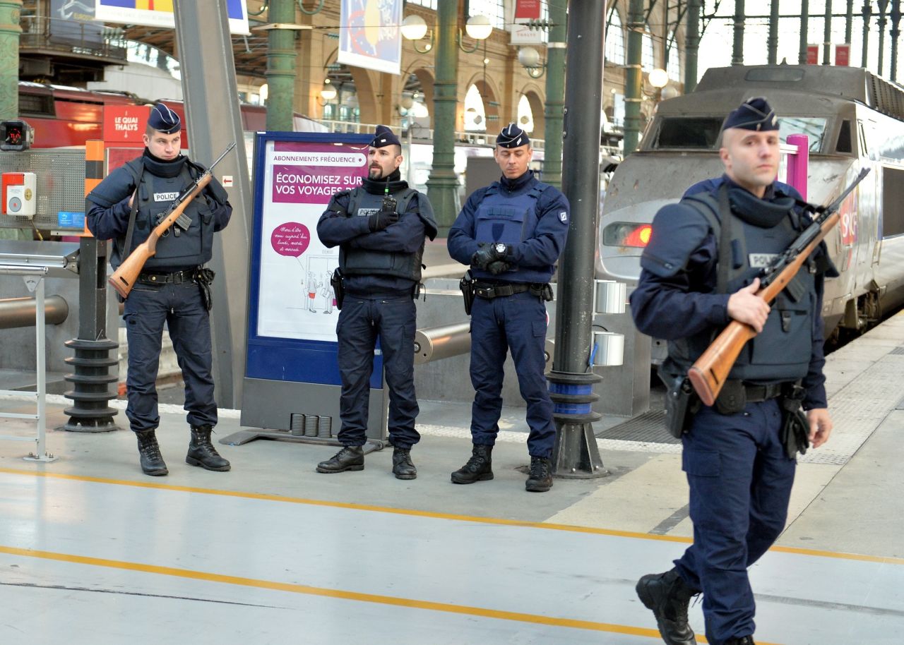 Police stand guard at a train station in Paris on November 14.