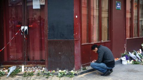A man places a candle in front of Le Carillon cafe in Paris on November 14.