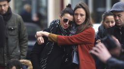Women comfort each other as they stand in front of the Carillon cafe, in Paris, Saturday, November 14 following Friday's terror attacks. 