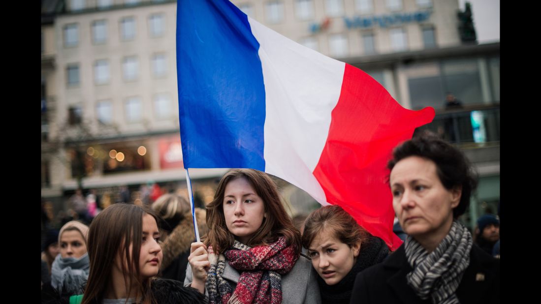 A woman holds a French flag during a gathering  in Stockholm, Sweden, on November 14.