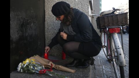 A woman lights a candle outside the French Consulate in Barcelona, Spain, on November 14.