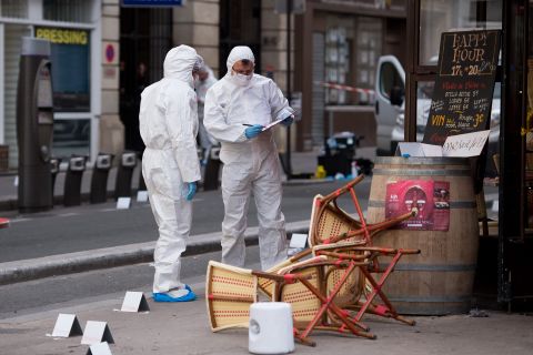 A forensic scientist works near a Paris cafe on Saturday, November 14, following a series of coordinated attacks in Paris the night before that killed scores of people. ISIS has claimed responsibility.