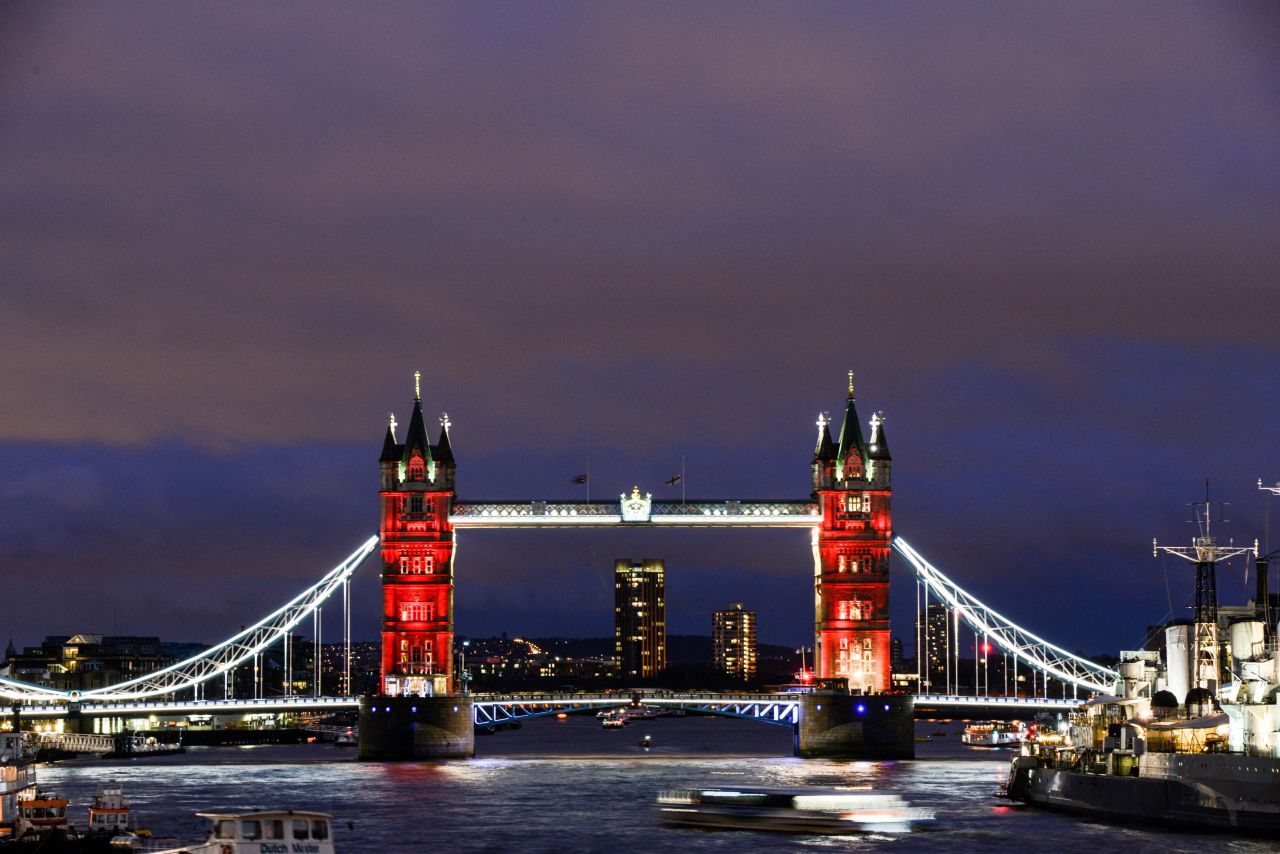 As the sun sets, London's Tower Bridge is lit in a succession of blue, white and red on November 14.