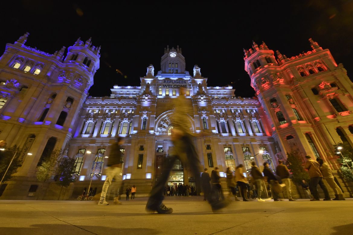 People cross the street past the Cibeles Palace, Madrid's town hall, on November 14.
