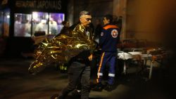 A victim walks outside the Bataclan theater in Paris, Friday Nov. 13, 2015. Well over 100 people were killed  in a series of shooting and explosions explosions. French President Francois Hollande declared a state of emergency and announced that he was closing the country's borders. (AP Photo/Jerome Delay)