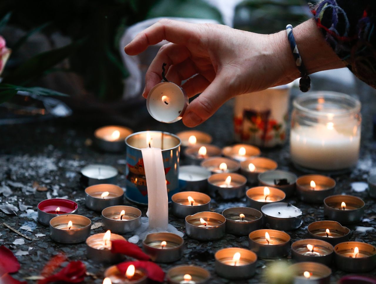 A woman lights candles at a memorial near the Bataclan theater in Paris on November 14.