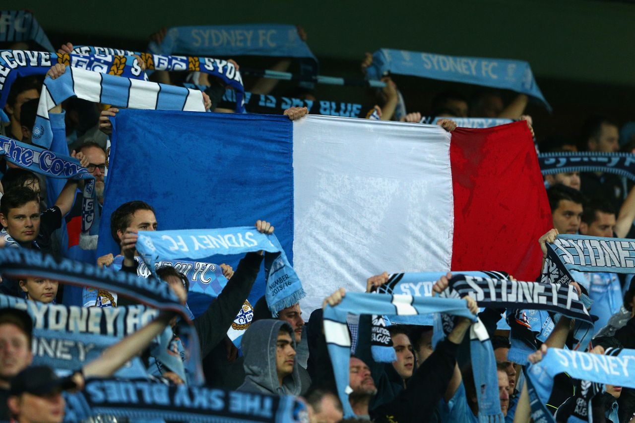 Sydney FC fans hold up a French flag during a moments silence for victims of the Paris terror attacks prior its match against Melbourne Victory at Allianz Stadium in Sydney. 