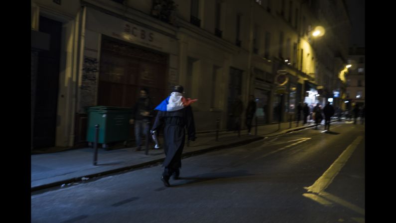 A man wearing a French flag walks through the streets of Paris on November 14. French President Francois Hollande has declared a state of emergency.