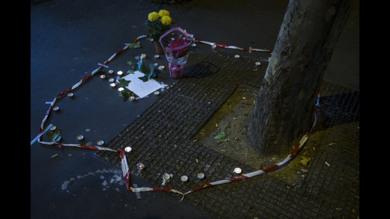 Candles and flowers are seen on November 14 at the spot where a victim died on the Rue de la Fontaine au Roi. Five people were killed in a shooting outside a bar in Paris' 11th district, according to prosecutor Francois Molins.