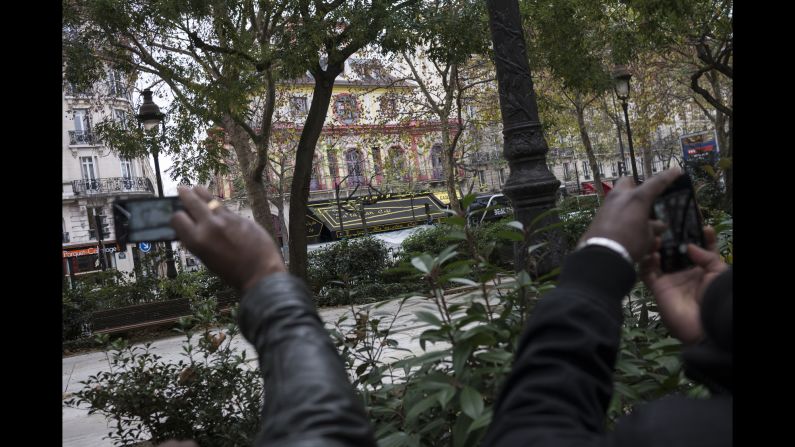 People take pictures on November 14 near the Bataclan concert hall, where more than 80 people were killed.