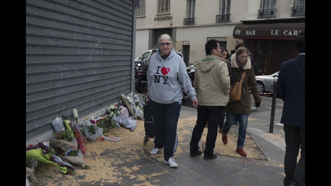 A woman walks past a memorial in Paris' 10th district November 14.