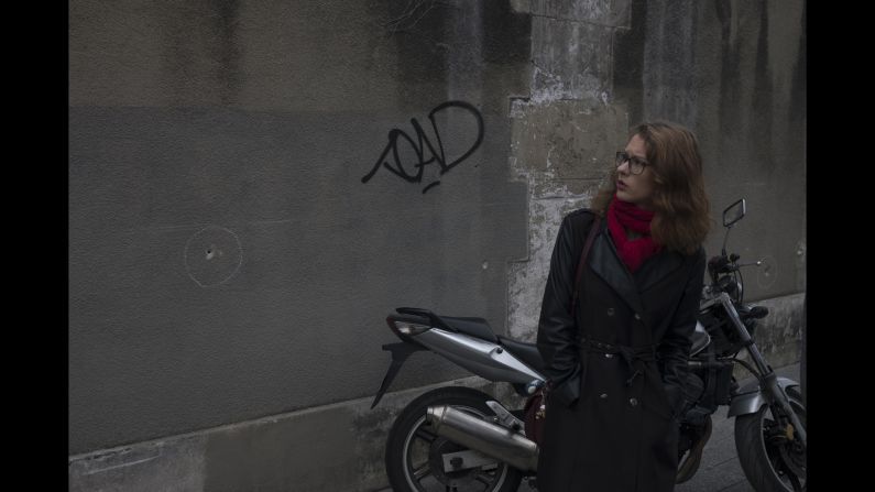 A woman observes bullet holes in a wall near the Paris restaurant Le Petit Cambodge on Saturday, November 14. 